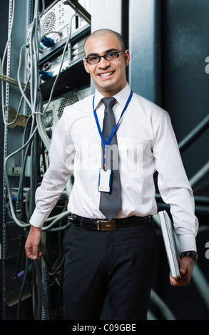 Portrait d'un technicien en souriant d'une salle de serveurs Banque D'Images