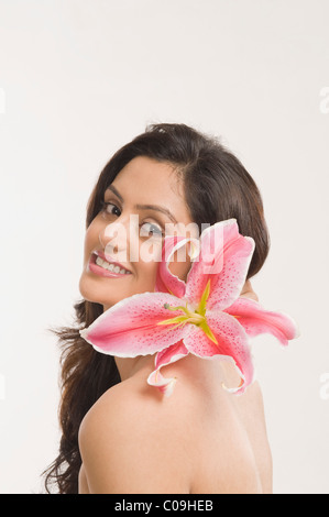 Woman smiling with a Tiger Lily flower Banque D'Images