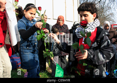 Les jeunes enfants donnent des roses rouges à pro Kadhafi manifestation à Londres Banque D'Images