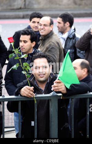 Manifestant Pro régime de Kadhafi est titulaire d'un drapeau vert et rose rouge au London Demo Banque D'Images