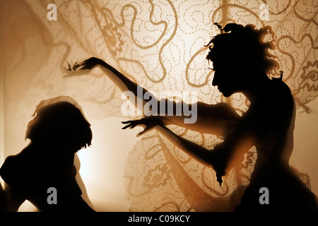 Femme envoûte un homme, projection d'ossature des chiffres sur un rideau lumineux, théâtre d'ombres, tour Kunstakademie Art Banque D'Images