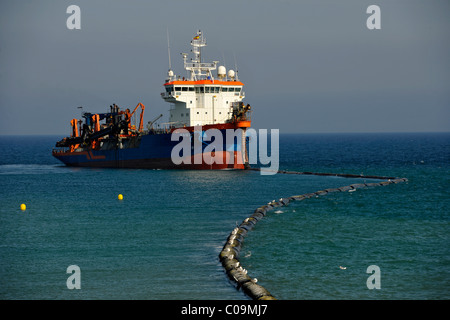 Drague par un flexible de pompage du sable sur une plage pour les plages ou la régénération des plages, Platja de Barceloneta, Barcelone Banque D'Images