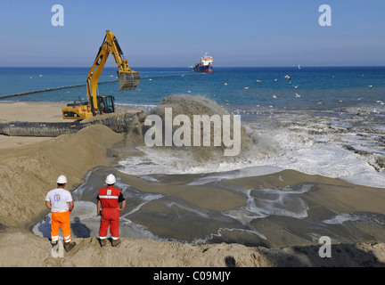 Drague par un flexible de pompage du sable sur une plage pour les plages ou la régénération des plages, Platja de Barceloneta, Barcelone Banque D'Images