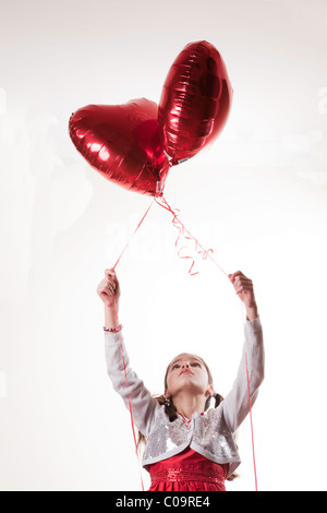 Happy girl holding a heart shaped balloon