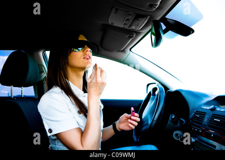 Jeune femme maquiller dans la voiture Banque D'Images