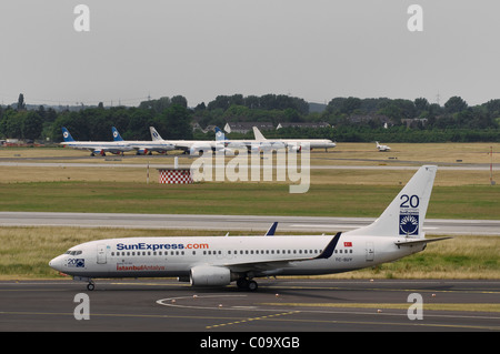 SunExpress Boeing 737-800 sur la piste, les avions à l'arrière, l'aéroport de Düsseldorf, Rhénanie du Nord-Westphalie, Allemagne, Europe Banque D'Images