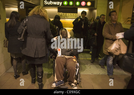 L'homme gravement handicapés en fauteuil roulant de se demander de l'argent à Grand Central Station, New York City. Banque D'Images