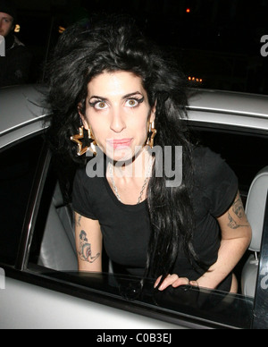 Amy Winehouse laisse Bungalow 8 discothèque et retourne à la maison. Sur son chemin elle s'arrête à un sweet shop à vous approvisionner en fournitures, et Banque D'Images