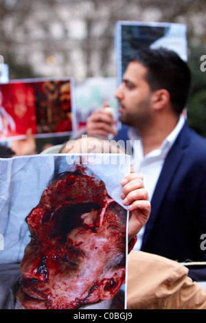 Contenu graphique. Manifestants devant l'ambassade du Bahreïn à Londres faire des photos des morts de l'agitation dans leur patrie Banque D'Images