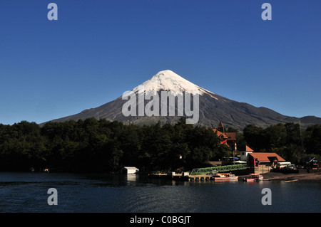 Vue du ciel bleu, du lac Todos Los Santos, du volcan Osorno cône de glace s'élevant au-dessus de la forêt, Hôtel Petrohue et Ferry Pier, Chili Banque D'Images