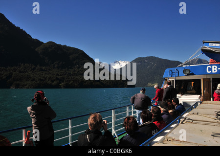 Vue du ciel bleu de touristes à la recherche vers le sommet du volcan Tronador blanc à partir d'un catamaran sur le lac Todos Los Santos, Chili Banque D'Images