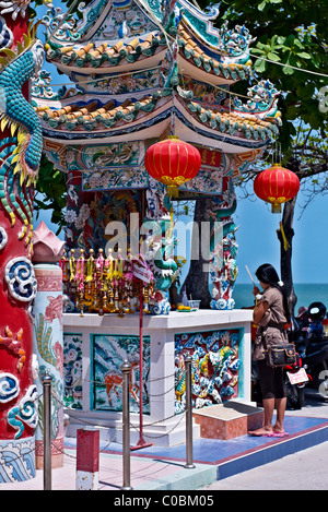 Une femme priant à un temple chinois. Temple de Hua Hin Thaïlande S. E. Asie Banque D'Images