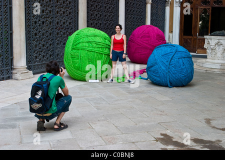 Man photographing woman par de grandes balles de laine Banque D'Images