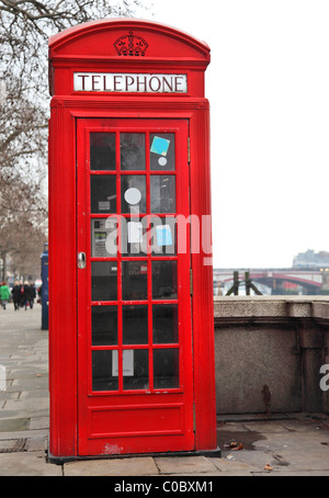 Boîte de téléphone rouge à côté de Londres Tamise Banque D'Images