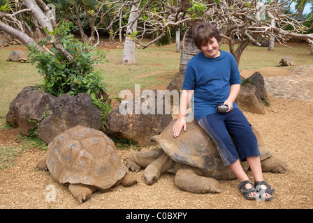 Garçon avec des tortues géantes La Vanille Crocodile Park, Ile Maurice Banque D'Images