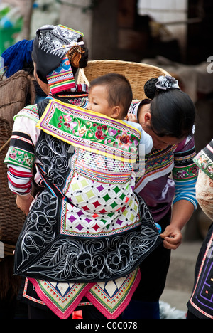 L'Asie, Chine, Yunnan, Honghe Préfecture, Yuanyang County, Panzhihua Ville. Yi femme avec bébé en sac à dos le jour du marché. Banque D'Images
