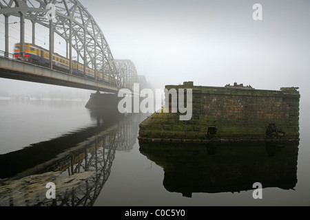 Train passant sur arches en acier pont ferroviaire sur la rivière Daugava sur un jour d'hiver brumeux, Riga, Lettonie Banque D'Images