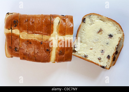 Hot Cross Bun Warburtons miche de pain avec une tranche beurrée prête pour Pâques isolé sur fond blanc Banque D'Images