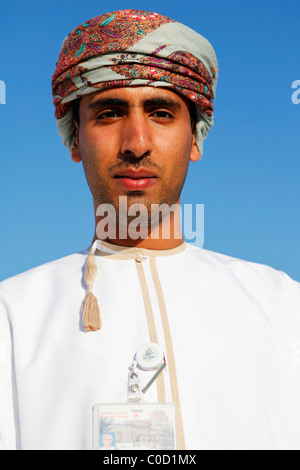 Un Omanais tour guide porte le costume national tout en menant une visite de Mascate, Oman. Banque D'Images