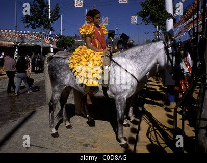 La foire de printemps de Séville, La feria de abril de Sevilla, Sevilla, Andalousie, espagne. Fille sur le cheval avec une robe traditionnelle flamenca, Banque D'Images