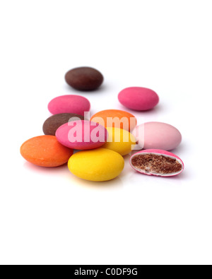 Chocolats enrobés de bonbons colorés avec une moitié en révélant le centre de chocolat. Banque D'Images