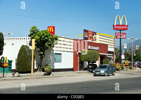 Cheerful red & white restaurant McDonald's à l'emblématique Golden Arches dans l'air clair à la périphérie de la ville d'Oaxaca au Mexique Banque D'Images