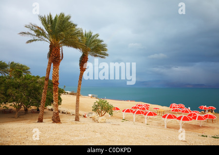 L'hiver sur la mer Morte. Un parapluie rouge, vert et violet thunderheads mer Banque D'Images