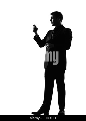 Silhouette caucasian business homme au téléphone la messagerie texte SMS pleine longueur sur studio isolé sur fond blanc Banque D'Images