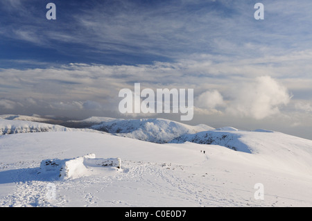 Ciel dramatique sur Helvellyn en hiver dans le Lake District, et Dollywagon Nethermost pike Pike en arrière-plan Banque D'Images