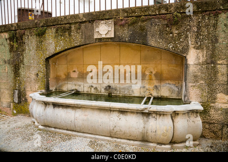 L'eau d'origine en pierre fontaine d'eau potable pour les animaux / animal verre creux dans le centre-ville de Ronda. Malaga, Espagne. Banque D'Images