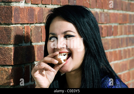 Woman eating a cadbury creme egg Banque D'Images