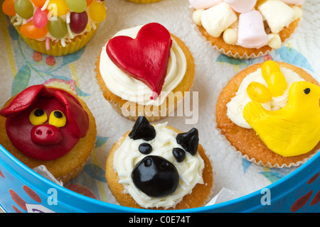 Une variété de fun cup cakes maison dynamiques stockées dans une boîte en fer. Banque D'Images