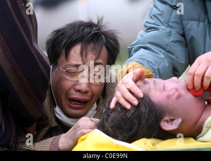 Un père pleure sur le corps de sa fille dans la région de Hanwang town ship de Mianzhu après le séisme de lundi Mianzhu, Chine - 15.05.08 Banque D'Images