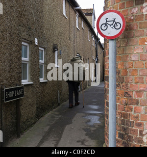 Seul un vieil homme marchant le long d'une ruelle dans les puits-next-the-Sea à Norfolk, en Angleterre. Banque D'Images