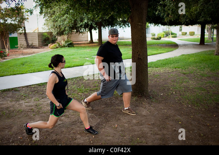 Reedley hallows, California, United States. Un adolescent obèse étend son tendon avec un entraîneur de conditionnement physique. Banque D'Images