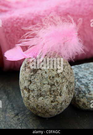 Plume rose sur les pierres et de serviette rose à l'arrière-plan spa concept Banque D'Images