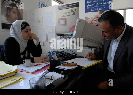 Un homme jordanien remplissant des documents au bureau du ONG MIZAN Groupe de droit pour les droits de l'homme à Amman, Jordanie Banque D'Images