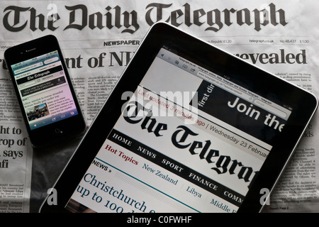 Un Apple iPad et iPhone d'Apple s'asseoir sur le dessus de la version imprimée du Daily Telegraph. Un exemple des nouveaux médias vs anciens médias. Banque D'Images