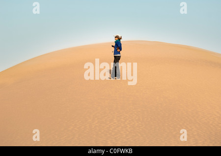 La figure solitaire debout sur une dune de sable dans le désert du Sahara Banque D'Images