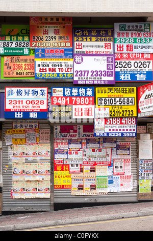 Panneaux publicitaires, affiches et bannières postés sur la façade d'un magasin dans le centre de Hong Kong., Chine Banque D'Images