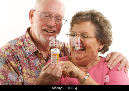 Senior Couple lit une bouteille de Prescription avec plaisir regard sur leurs visages tous sur un fond blanc. Banque D'Images