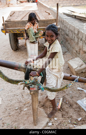 Heureux les pauvres jeunes filles de la rue indienne caste inférieure jouant sur une charrette. Soeurs. L'Andhra Pradesh, Inde Banque D'Images