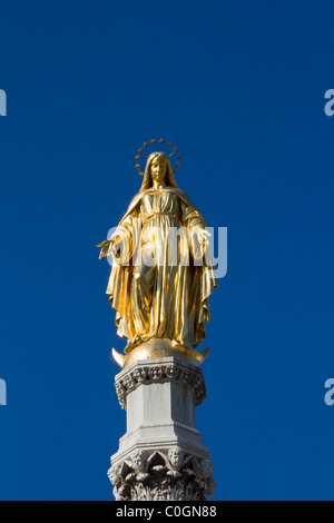 Vierge Marie statue en or against a blue sky Banque D'Images