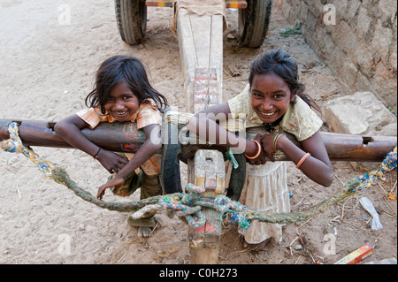 Heureux les pauvres jeunes filles de la rue indienne caste inférieure jouant sur une charrette. Soeurs. L'Andhra Pradesh, Inde Banque D'Images