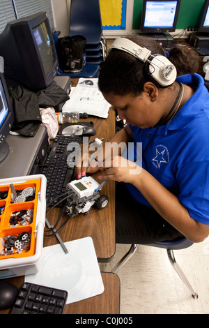 Middle school girl afro-américain parle à l'enseignant à propos de sa voiture radio-commandée en robotique à l'école classe Ann Richards Banque D'Images