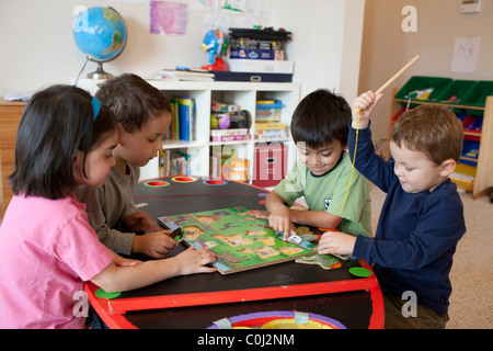 L'américano-mexicaine, les enfants âgés de six, cinq, quatre et trois, coopérer pour mettre en place un puzzle en bois à Austin au Texas Banque D'Images