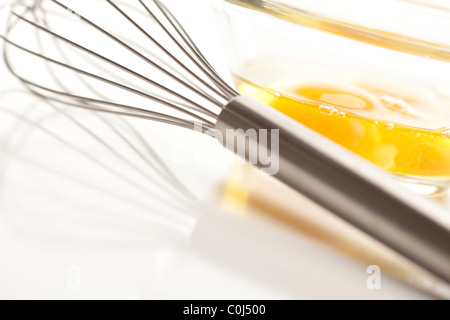 Oeufs dans un bol en verre sur un fond blanc réfléchissant. Banque D'Images