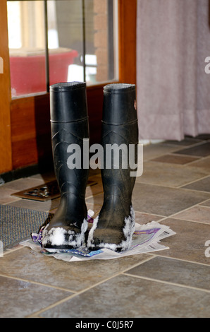 Une vieille paire de bottes en caoutchouc Balle de neige sur eux reste sur un journal à l'intérieur. USA. Banque D'Images