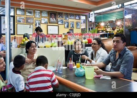 Groupe de la famille à une table de restaurant à l'intérieur de l'ancien marché de Benito Juarez, la Ville d'Oaxaca au Mexique Banque D'Images