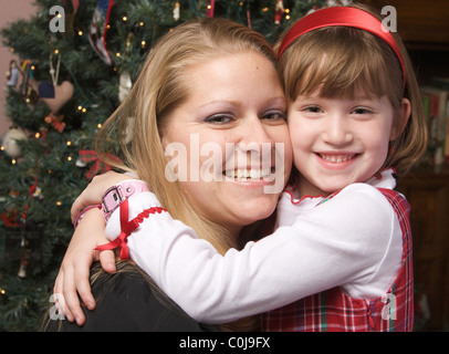 La mère et l'enfant dans ses bras devant un arbre de Noël. Banque D'Images